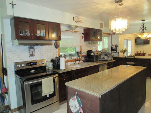 kitchen with decorative backsplash, a center island, appliances with stainless steel finishes, and an inviting chandelier