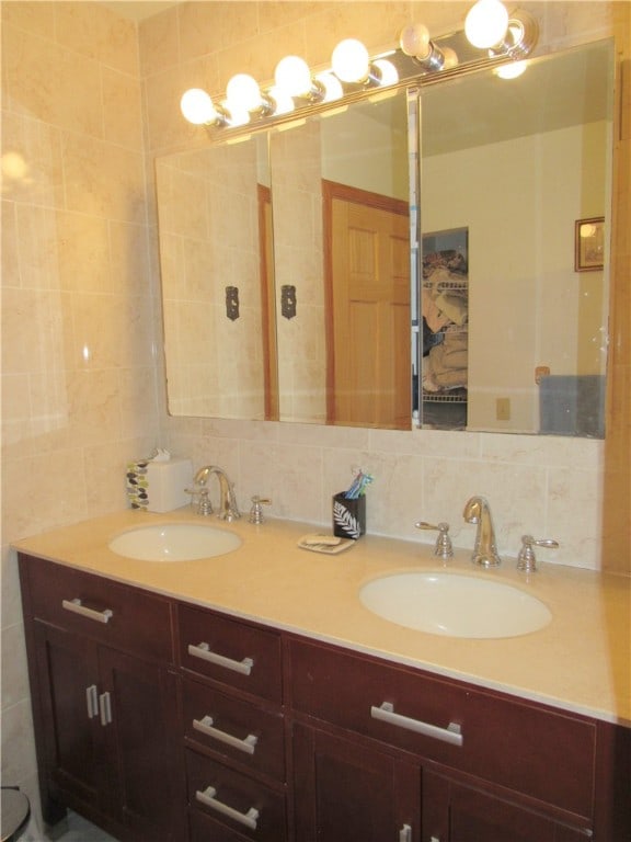 bathroom with vanity and tasteful backsplash