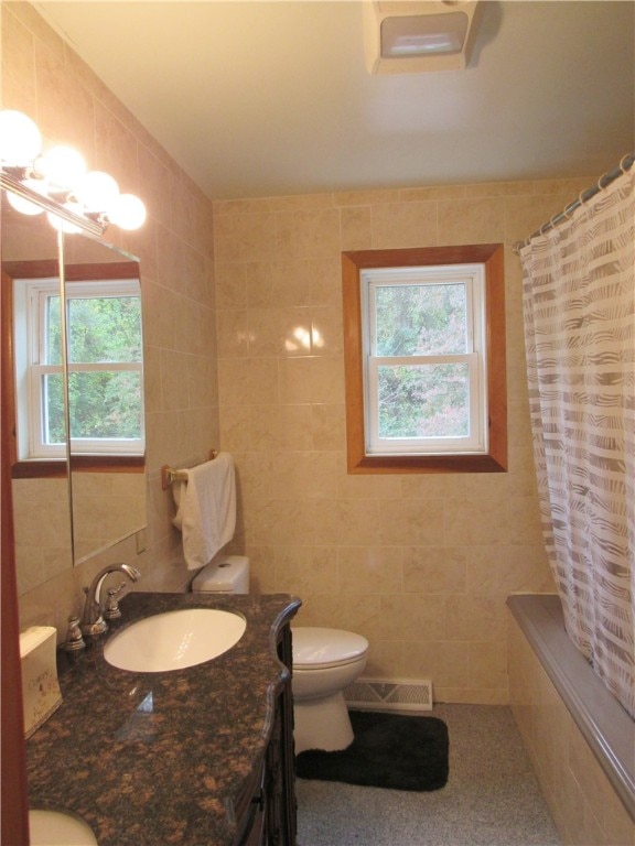 bathroom featuring tile walls, a wealth of natural light, vanity, and toilet