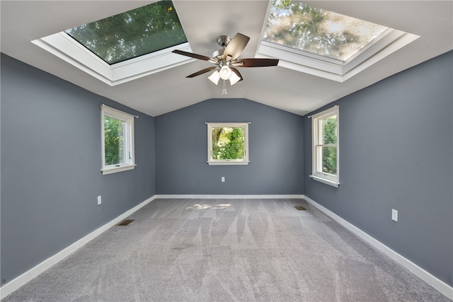 interior space with ceiling fan and lofted ceiling with skylight