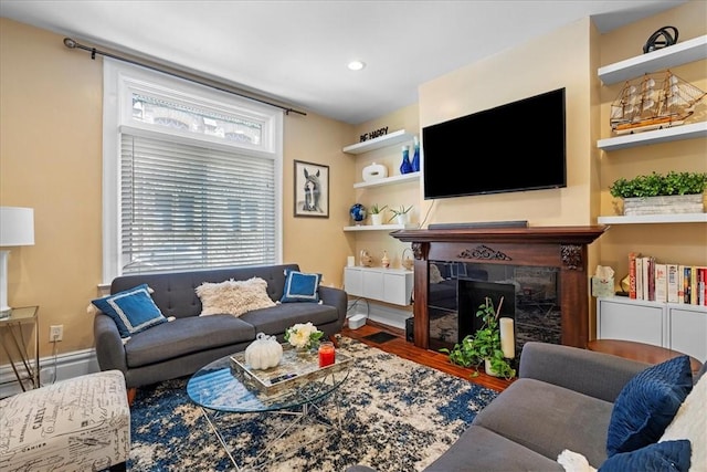 living area featuring recessed lighting, a premium fireplace, and wood finished floors