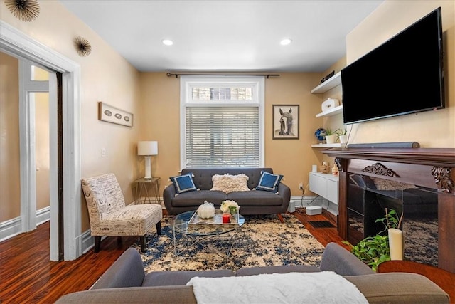 living area featuring recessed lighting, baseboards, wood finished floors, and a fireplace