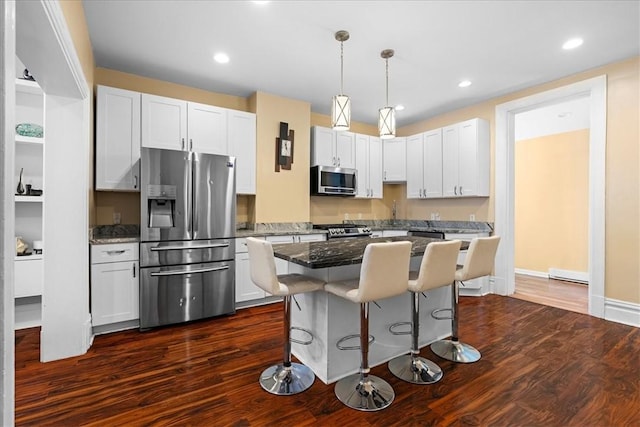 3943 Perrysville Ave, Observatory Hill, PA 15214 - kitchen featuring a center island, dark stone counters, a kitchen bar, dark wood-style floors, and stainless steel appliances
