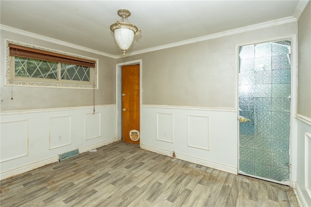 unfurnished room featuring light wood-type flooring and crown molding