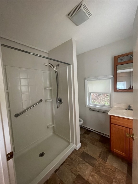 bathroom featuring tile patterned flooring, toilet, a shower, and vanity