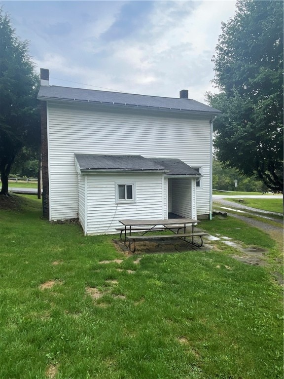 rear view of house featuring a lawn