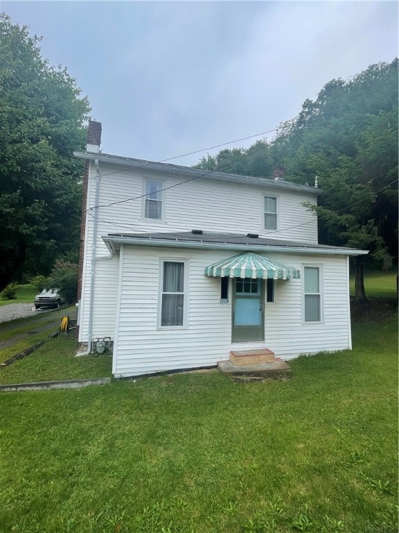 rear view of property featuring a yard