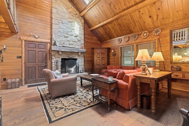 living room featuring beamed ceiling, a fireplace, wooden walls, wood ceiling, and hardwood / wood-style flooring