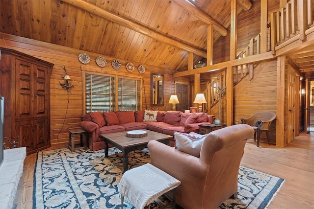 living room with vaulted ceiling with beams, wood ceiling, light hardwood / wood-style flooring, and wooden walls