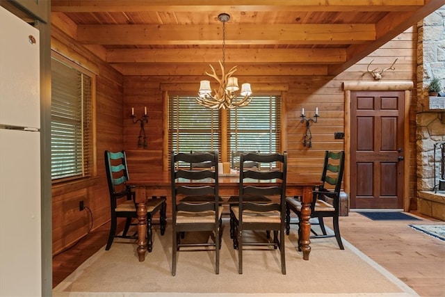 dining room with a notable chandelier, beamed ceiling, wooden ceiling, and wood-type flooring