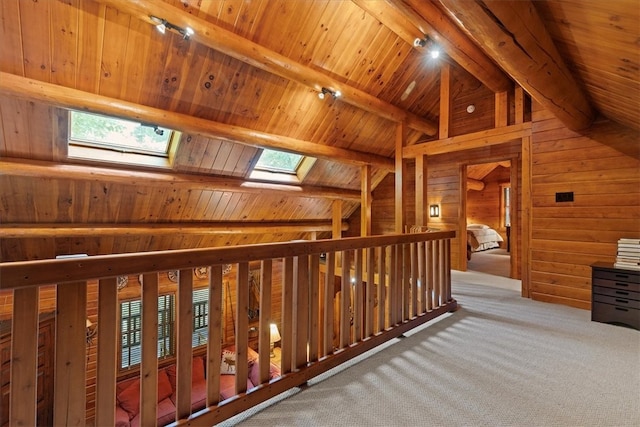 hall featuring wood ceiling, carpet floors, vaulted ceiling with skylight, and wood walls