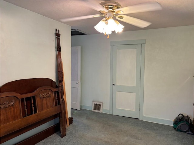 carpeted bedroom with visible vents, baseboards, and a ceiling fan