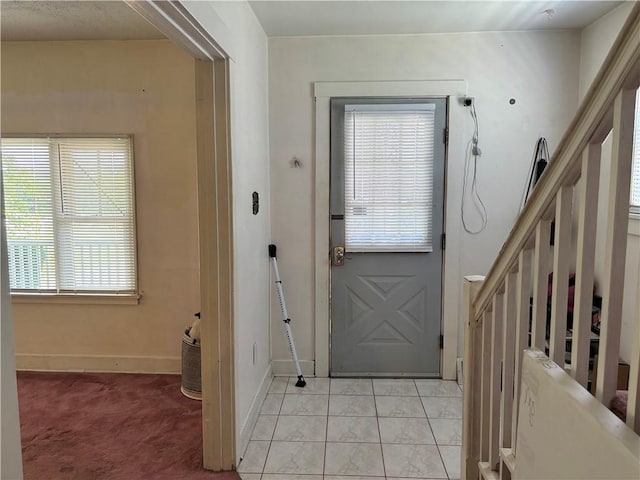 doorway to outside with stairway and baseboards