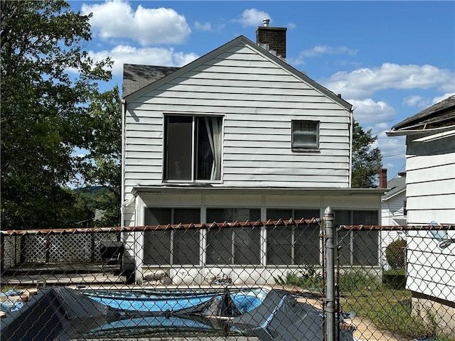 exterior space with a gate, a chimney, and fence