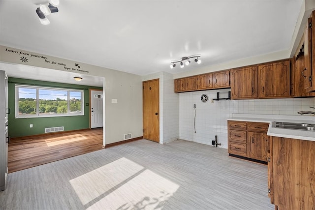 kitchen with sink, track lighting, and light hardwood / wood-style floors