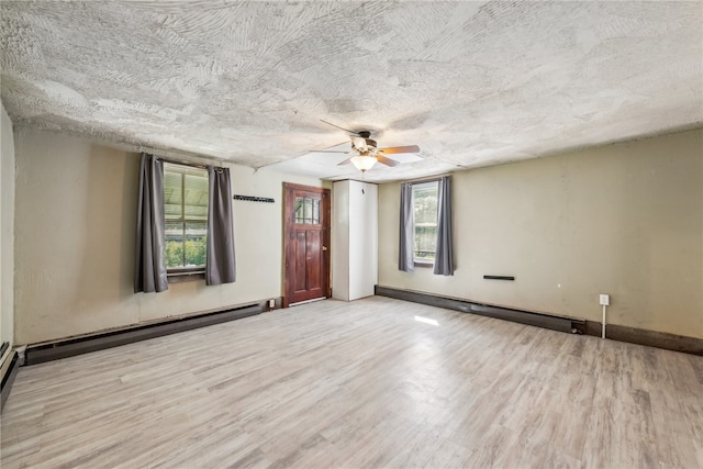 spare room with ceiling fan, a textured ceiling, light hardwood / wood-style flooring, and a baseboard radiator