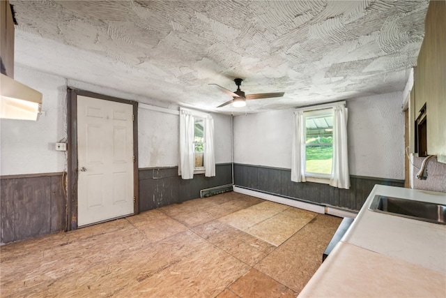 interior space featuring ceiling fan, sink, light tile patterned flooring, and a healthy amount of sunlight