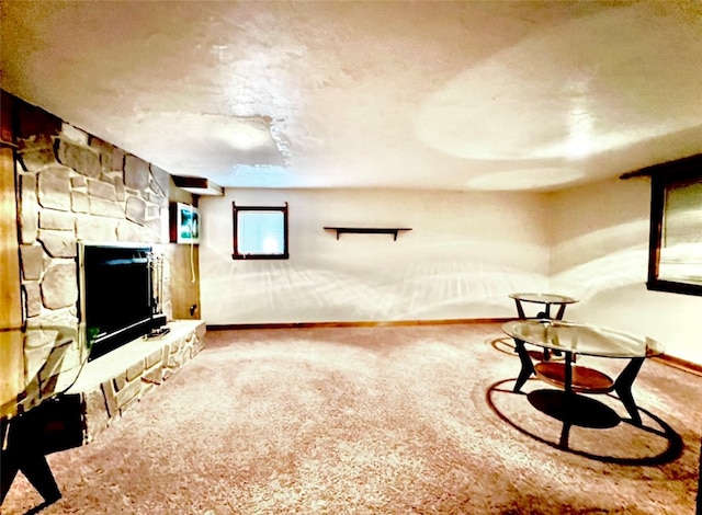 carpeted living room with a fireplace and baseboards