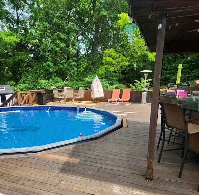 outdoor pool featuring outdoor dining space and a deck
