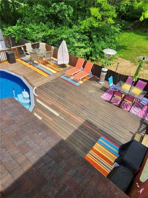 view of pool featuring fence, outdoor dining area, a fenced in pool, and a wooden deck