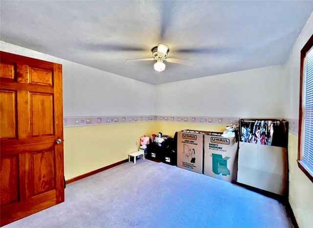 game room featuring carpet flooring, a ceiling fan, and baseboards