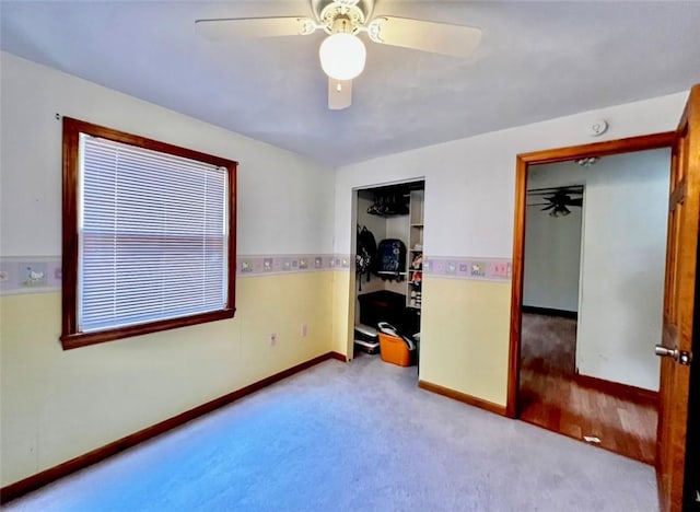 unfurnished bedroom with a closet, carpet, baseboards, and ceiling fan