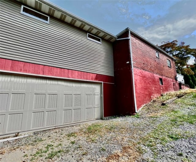 exterior space featuring a garage and brick siding