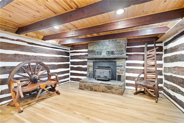 living room with wood ceiling, beam ceiling, light hardwood / wood-style floors, and a wood stove