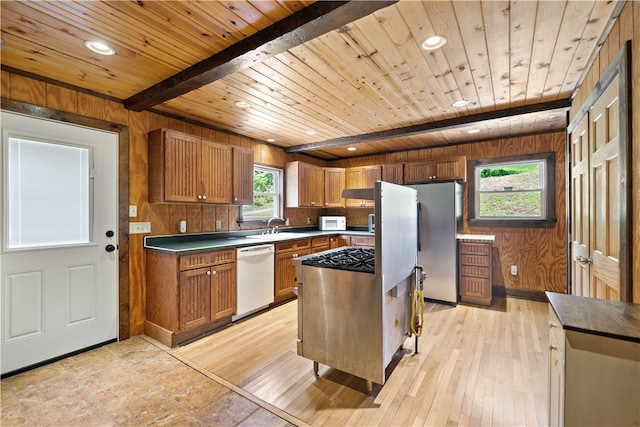 kitchen with white appliances, wooden walls, wooden ceiling, and light hardwood / wood-style flooring