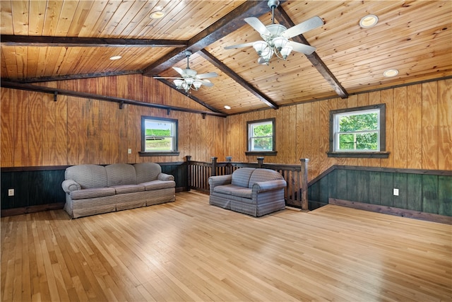 unfurnished living room featuring wood walls, light hardwood / wood-style flooring, vaulted ceiling with beams, and wooden ceiling