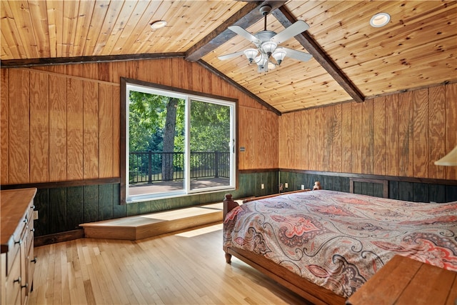 unfurnished bedroom with vaulted ceiling with beams, light wood-type flooring, wooden ceiling, wooden walls, and ceiling fan