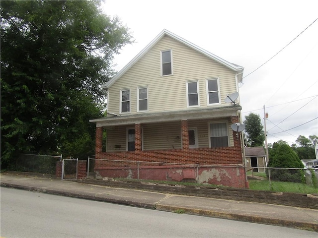 113 E Church Ave, Masontown, PA 15425 - view of front of property with covered porch, brick siding, fence private yard, and a gate