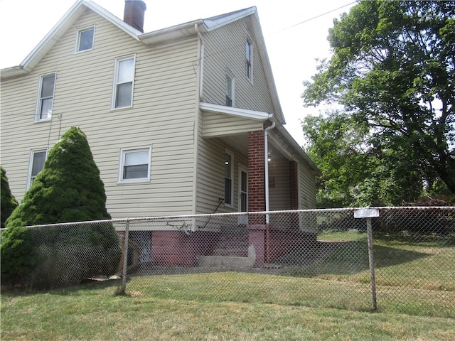 view of side of home with a yard