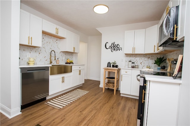 kitchen featuring decorative backsplash, white cabinetry, hardwood / wood-style floors, and stainless steel appliances