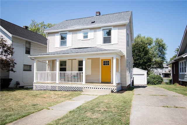 view of front facade with a garage, a front lawn, a porch, and an outdoor structure