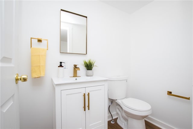 bathroom featuring wood-type flooring, toilet, and vanity