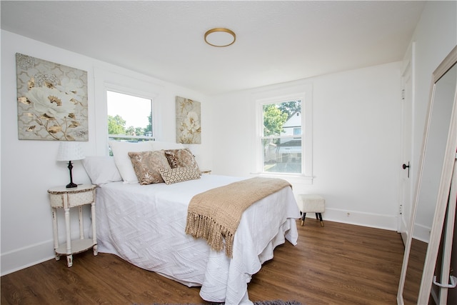 bedroom with dark wood-type flooring