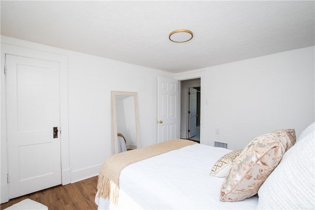 bedroom with dark hardwood / wood-style flooring