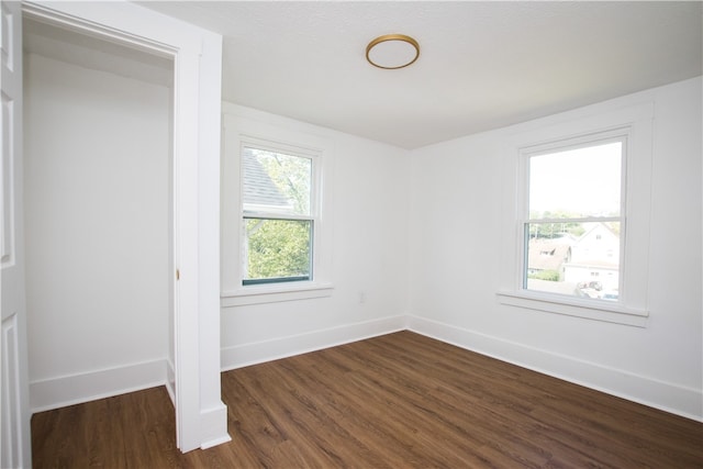 unfurnished room with dark hardwood / wood-style flooring