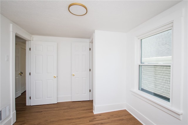 unfurnished bedroom featuring hardwood / wood-style flooring and a textured ceiling