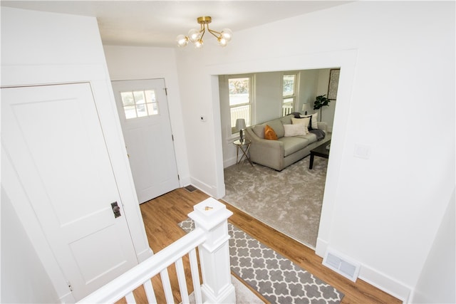 entrance foyer with light wood-type flooring and an inviting chandelier