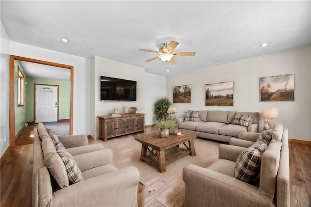 living room with light hardwood / wood-style flooring and ceiling fan