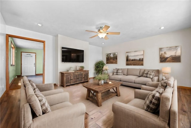 living room featuring baseboards, light wood finished floors, a ceiling fan, and recessed lighting