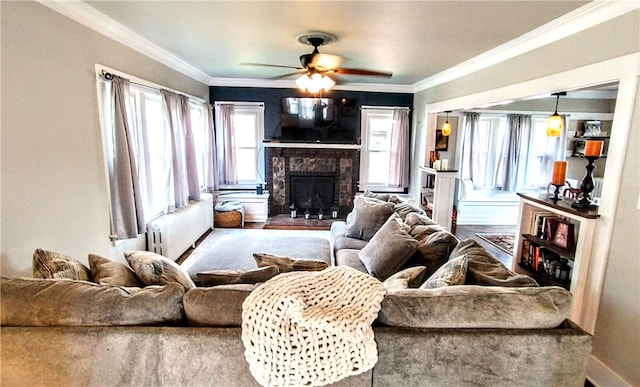 living room with hardwood / wood-style flooring, a brick fireplace, radiator heating unit, and a healthy amount of sunlight