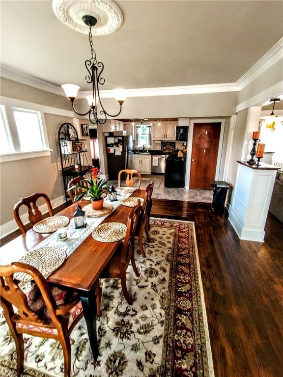 dining area featuring a wealth of natural light, dark hardwood / wood-style floors, a chandelier, and ornamental molding