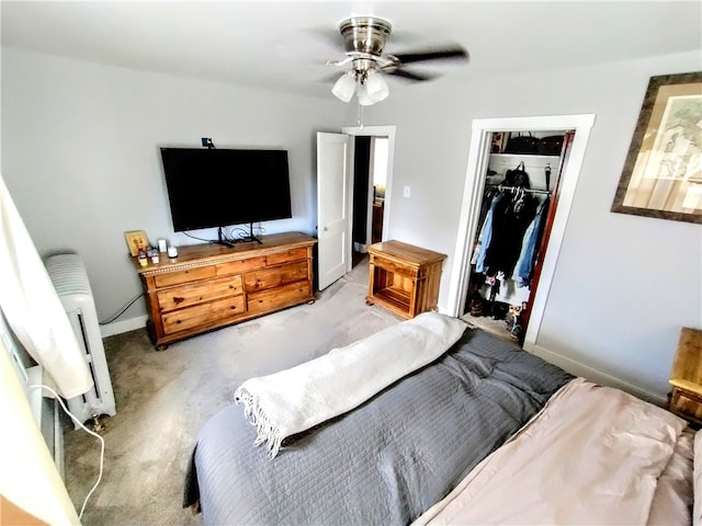 carpeted bedroom featuring ceiling fan, a closet, radiator heating unit, and a walk in closet