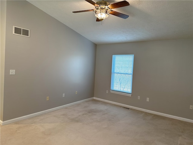 carpeted empty room featuring ceiling fan, lofted ceiling, and a textured ceiling