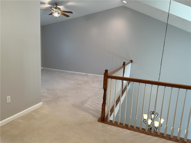 staircase with a textured ceiling, ceiling fan with notable chandelier, carpet, and vaulted ceiling