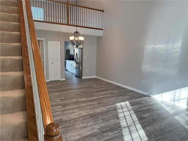 interior space featuring a chandelier, a high ceiling, and dark hardwood / wood-style floors