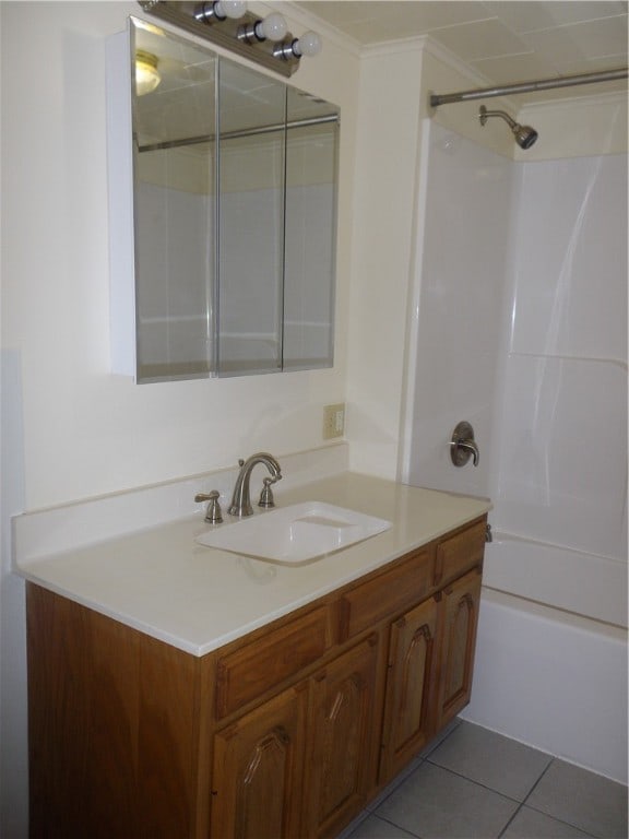 bathroom featuring bathing tub / shower combination, tile patterned floors, ornamental molding, and vanity